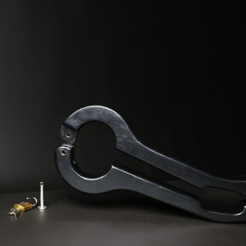 Scrotum to arms black wooden pillory